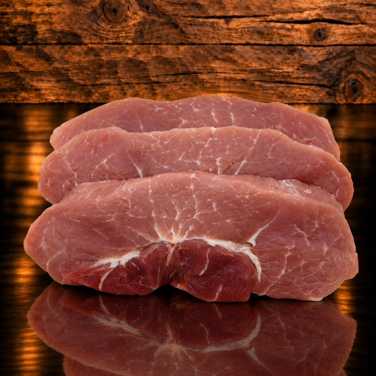 Schweinshuftplätzli auf Holzschneidebrett